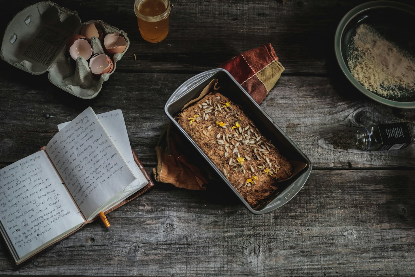 Freshly baked bread with baking ingredients and a handwritten notebook.